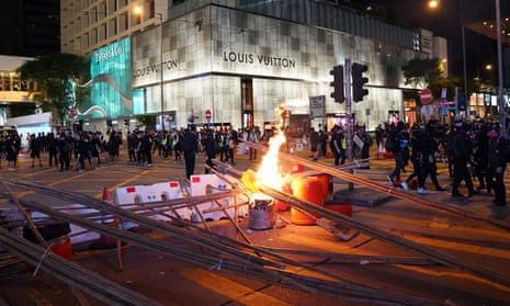 Hong Kong protesters block roads and disrupt traffic on Saturday, after earlier violence saw the offices of China’s state-run news agency Xinhua vandalised.