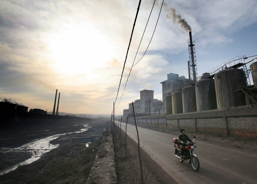 A cyclists passes in front of a factory in the Chinese town of Yangquan.
