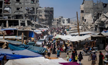 Displaced Palestinians make their way through a street in Khan Younis