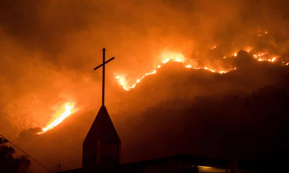 Flames from a wildfire advance on a church in California