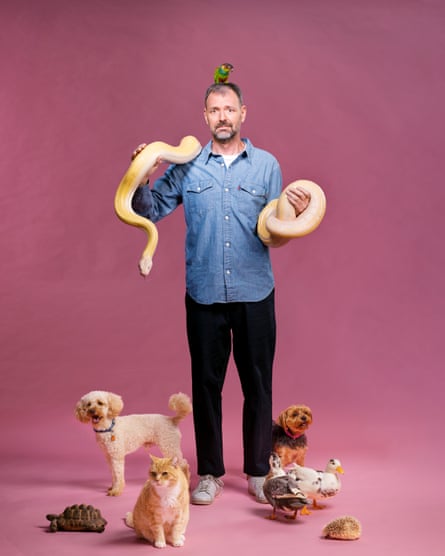Tim Dowling with a host of animals: a cat, two dogs, two ducks, a tortoise, a snake, a hedgehog and a parrot 