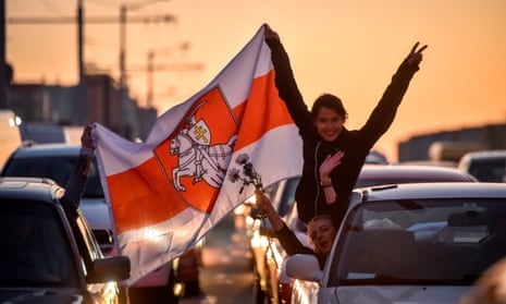 Demonstrators in cars in Minsk hold aloft Pahonia flag, a patriotic emblem of Belarus