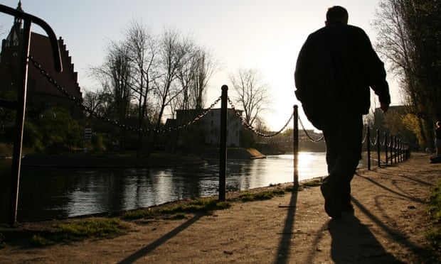 Elderly man walking by a canal