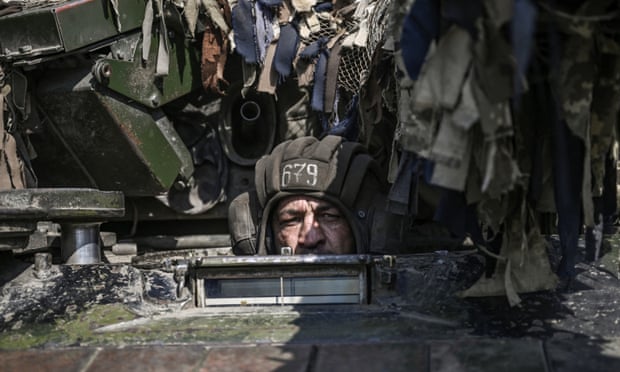 A Ukrainian serviceman drives a tank towards the front line in Donbas on 14 June.
