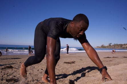 A man crawls on all fours on the beach