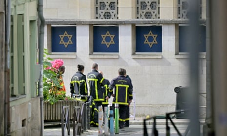 Fire brigade members stand by a synagogue in the Normandy city of Rouen where French police have killed earlier an armed man who was trying to set fire to the building.