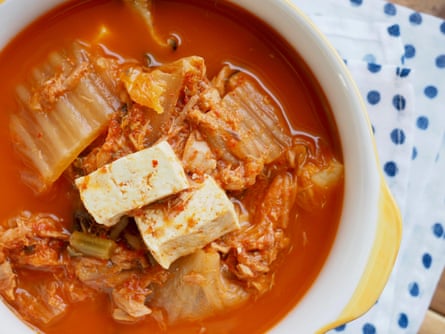 A bowl of kimchi stew with cabbage and tofu