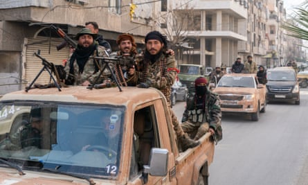 Rebels riding on the back of a pickup truck driving along a street