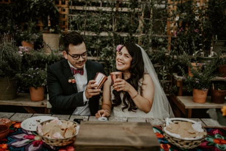couple holds up cups at wedding table