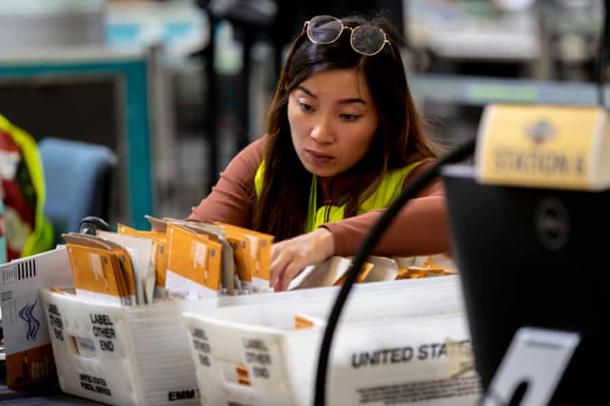 Un travailleur électoral vérifie les signatures sur les bulletins de vote postal le jour du rappel.