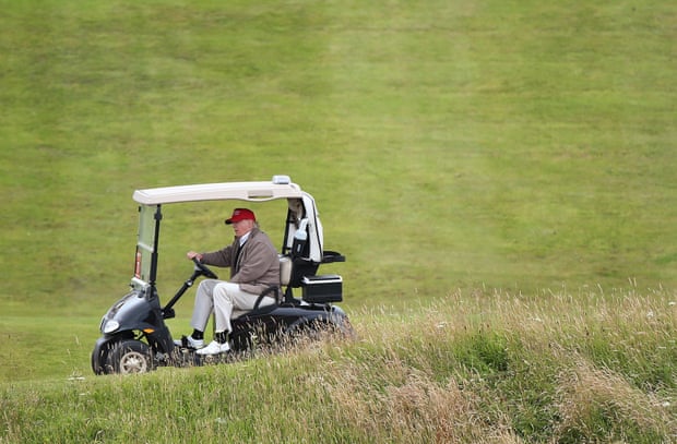 FILE - In this July 31, 2015 file photo, Republican presidential candidate Donald Trump drives his golf buggy during the second day of the Women's British Open golf championship on the Turnberry golf course in Turnberry, Scotland. Trump wants to build another huge wall, this time to keep out the rising seas threatening to swamp his luxury golf resort in Ireland. He has called climate change a con job and a hoax. But in a permit application filed earlier this month in County Clare, Ireland, the Trump International Golf Links and Hotel is seeking permission to build a two-mile-long stone wall between it and the Atlantic Ocean. (AP Photo/Scott Heppell, File)