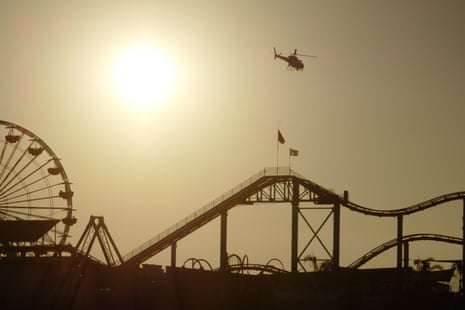Rising above the rollercoaster – a helicopter soars into the sunset at Santa Monica pier