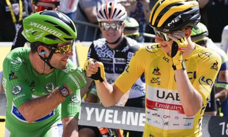 Slovenia’s Tadej Pogacar, wearing the overall leader’s yellow jersey, greets Britain’s Mark Cavendish, wearing the best sprinter’s green jersey.