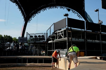 two people setting up materials in a stage-like arena space