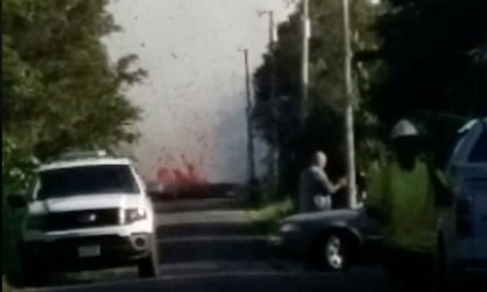 Lava spurts from the ground as emergency vehicles attend the scene.