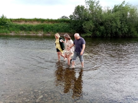 Hayley (centre) with her sister Jo and uncle Barry, pictured at Cliff's ceremony on the River Wye. The three of them are holding hands and walking in the water