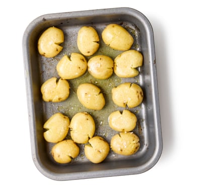 04a Felicity Cloake’s perfect roast new potatoes. Remove the hot tin from the oven. If you can do so with your hob, put it, set it on a low heat on the hob to keep warm while you turn each potato in turn in the hot oil to coat. Spread out the potatoes as much as possible, then season generously with salt.