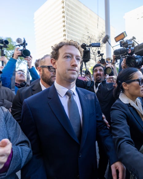 Mark Zuckerberg walks through a crowd of photographers and reporters outside a courthouse