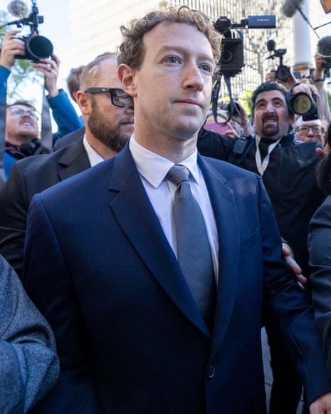 Mark Zuckerberg walks through a crowd of photographers and reporters outside a courthouse