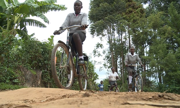 Kenyan school girls riding to school on bicycles