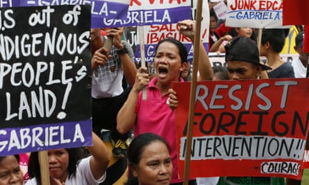 Protesters display placards after forcing their way to the gates of the US embassy in Manila