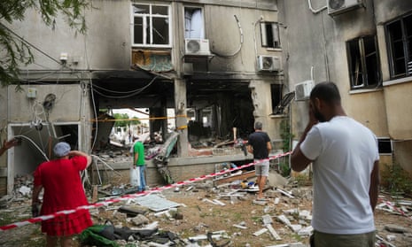 Israelis inspect a damaged residential building in Ashkelon after it was hit by a rocket fired from the Gaza Strip on Monday