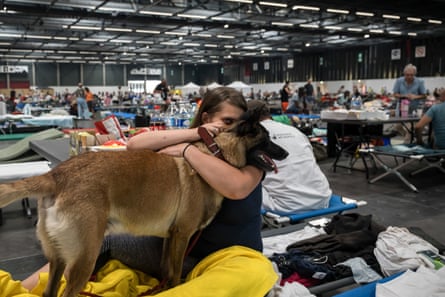 A woman with her arms around a dog.