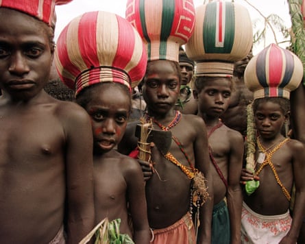 Children wearing traditional clothes including bulbous colourful hats stand in a group