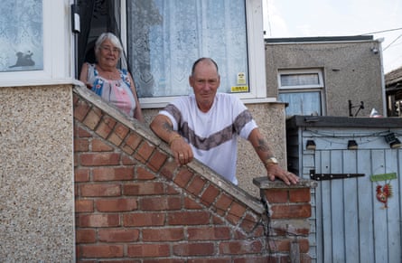 They stand on the steps outside their home, posing for the camera