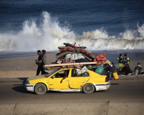 Displaced Palestinians flee southward from Gaza City with belongings on overloaded car