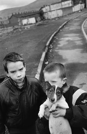 two boys and a jack russell terrier with distant houses and hills