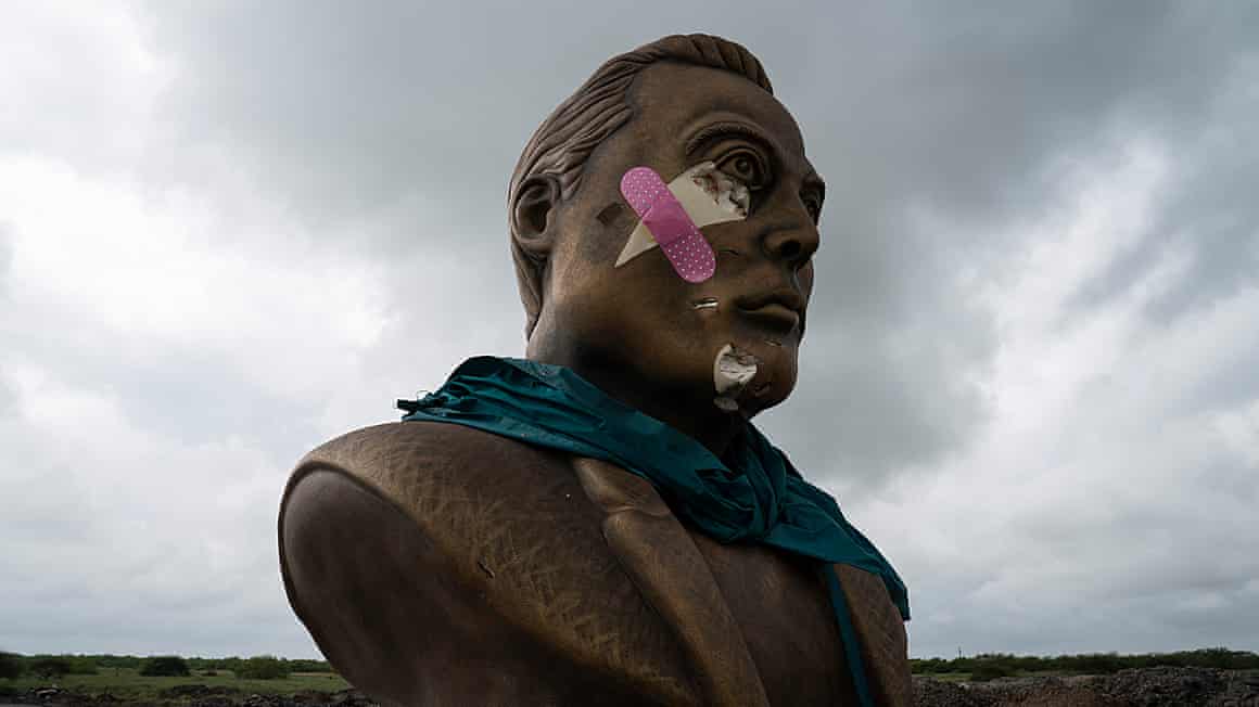 Pink and white plasters stuck across the face of the bust