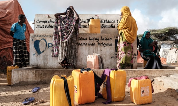 Displaced Somali women fill jerrycans at a water point in Mogadishu