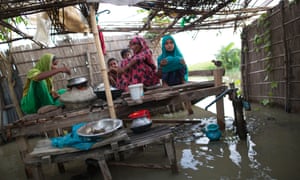A family cooks food on a cot in flood-hit Lalmonirhat, Bangladesh – a country among the most vulnerable to the consequences of climate change.