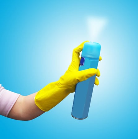 A box of air freshener squeezed by a yellow gloved hand on a blue background.