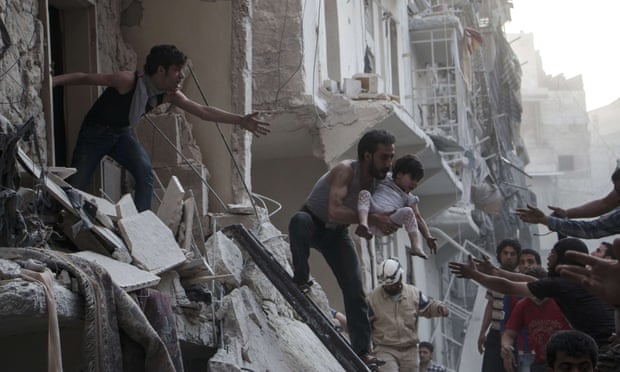 A man carries a child from a building following a reported barrel bomb attack