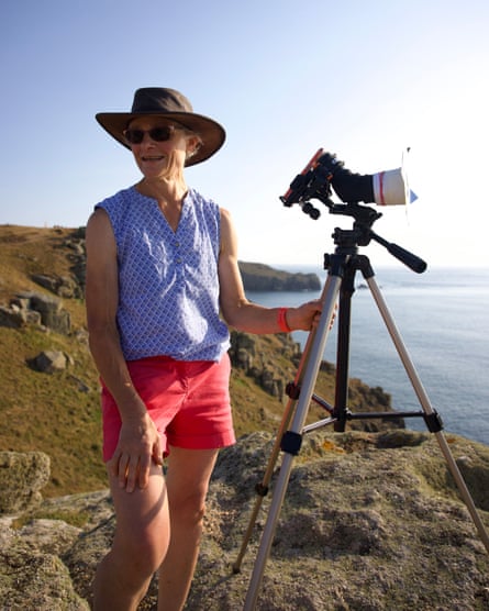 A woman on a cliff with phone attached to large lens