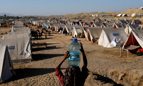 A girl carries a bottle of water at a camp for people displaced by floods in Sehwan, Pakistan, in September