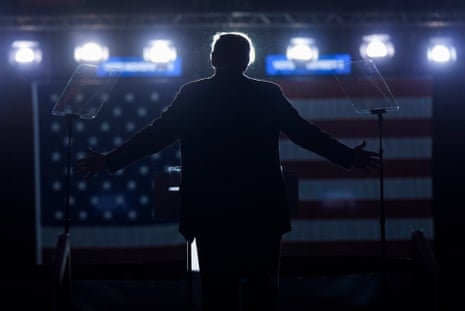 a silhouette of a man speaking with his hands outstretched