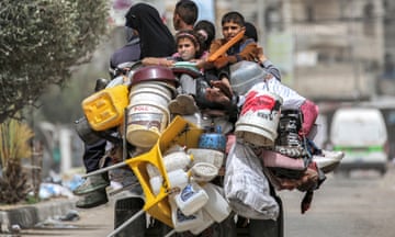 A man, woman and children flee Rafah in southern Gaza on a tricycle on Saturday