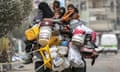 A man, woman and children flee Rafah in southern Gaza on a tricycle loaded with belongings on Saturday.