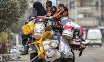 A man, woman and children flee Rafah in southern Gaza on a tricycle loaded with belongings on Saturday.