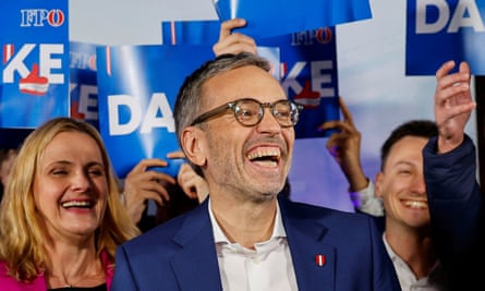 Herbert Kickl looking very happy with supporters and banners behind him