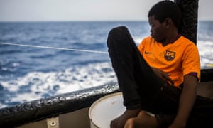 Khingsley Dokowada, nine, from Central African Republic, rests on the deck of a Spanish NGO vessel.