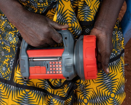 Detail of a woman holding one of the torches she uses to scare elephants at night.