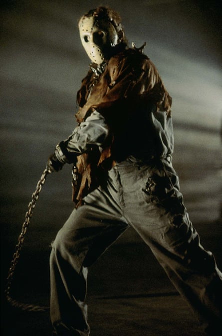 Kane Hodder as Jason Voorhees, looking threatening in a creepy mask and carrying a chain.