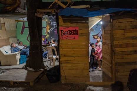 Children can be seen through a slightly open door while in the next room two men sit on a sofa.