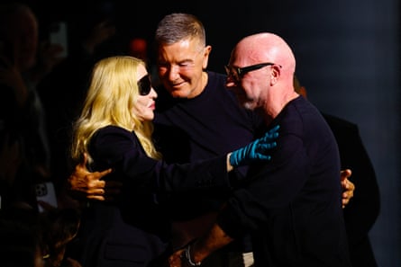 Madonna, Stefano Gabbana and Domenico Dolce, all dressed in black, talk together in a huddle