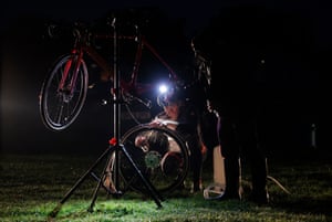 A competitor washes his bike under lights from his car