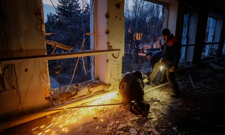 Local residents repair central heating at a children's sports centre in Ukraine’s Donetsk city after it was hit during three days of Russian shelling that killed nine people and injured 20
